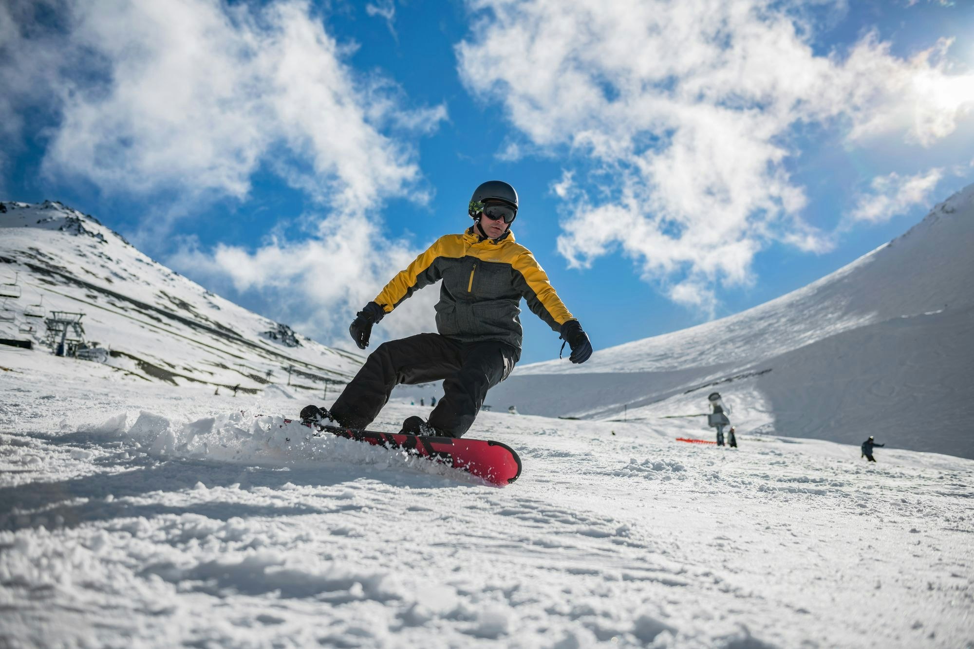 Up your cardio by working out on the slopes Image of a man snowboarding downhill