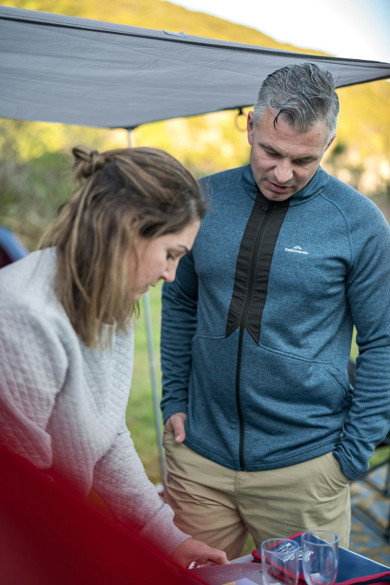 The Expedite Fleece Jacket is a casual but smart addition to your suitcase. Image of a man wearing the Expedite as he chats to a woman who is preparing food.