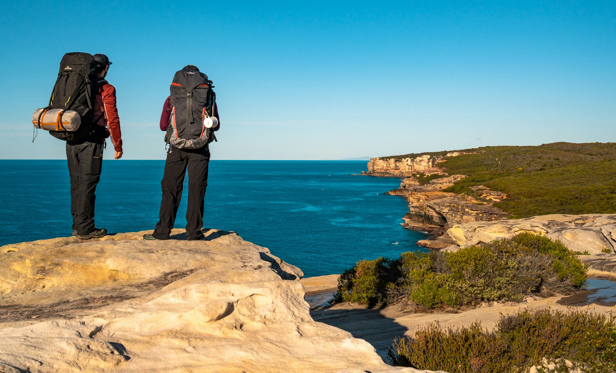 If you're lucky, you might spot a humpback whale. Image of Jarryd & Alesha standing on a ledge looking out over the ocean from the Royal National Park