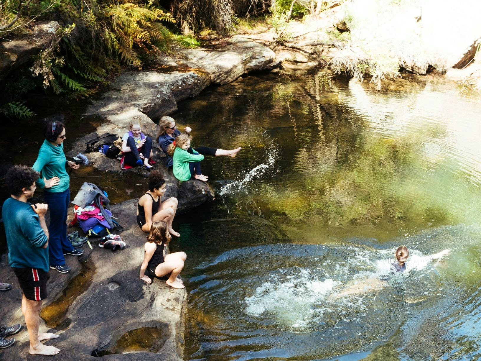 After a family hike to Kingfisher Pool in NSW, Sarah Allely found relief from the symptoms of a brain injury. People swimming at a water hole