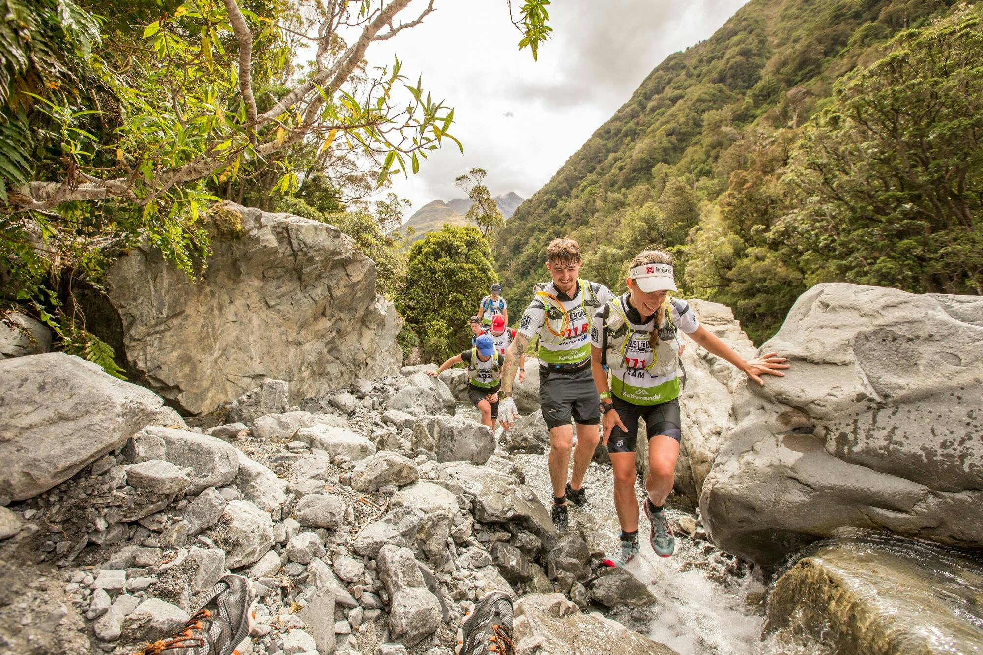People running across a stream in New Zealand