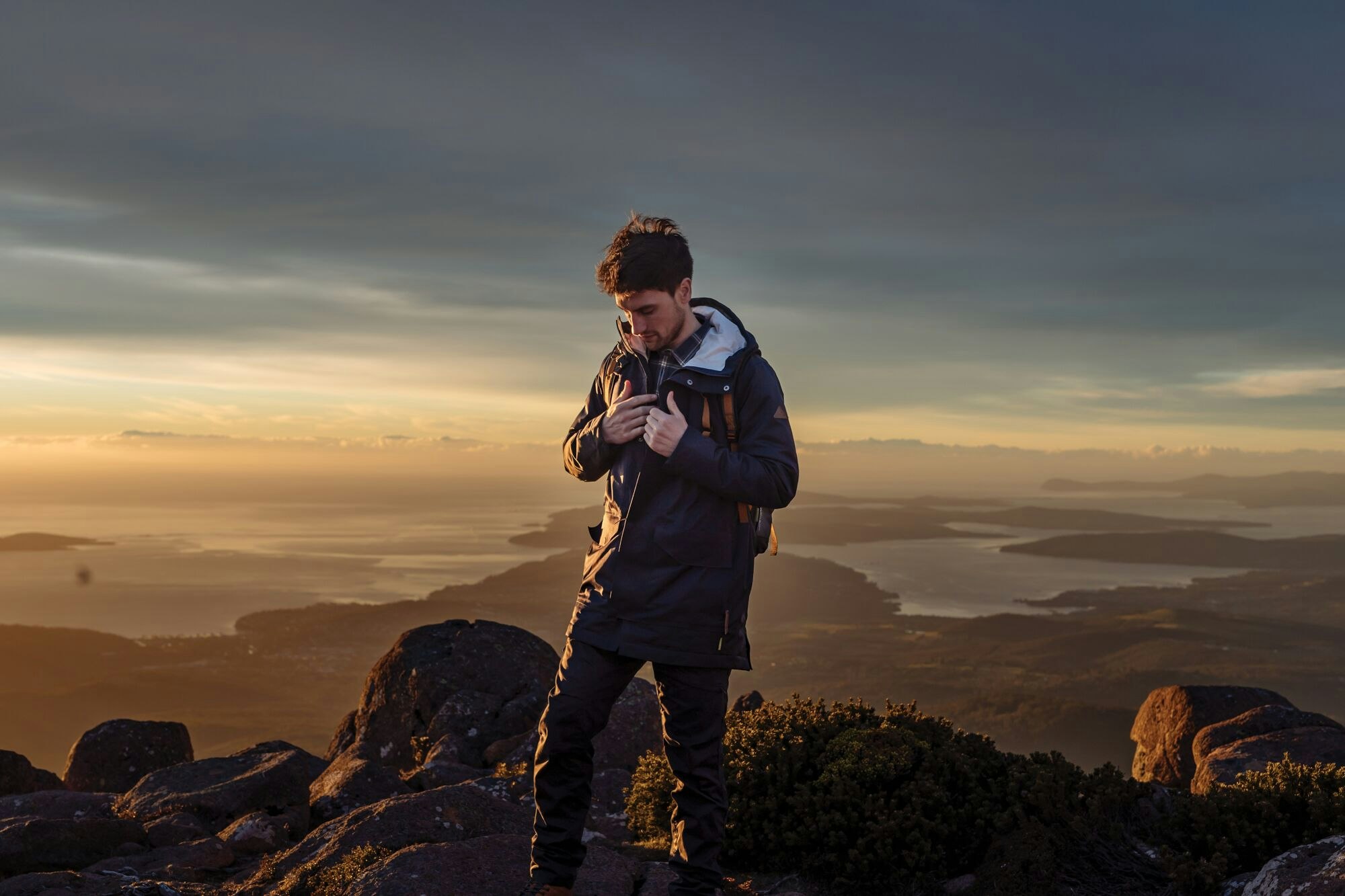 Eco-friendly Stockton Jacket Image of man on a mountain top inspecting the layers of the Stockton Jacket