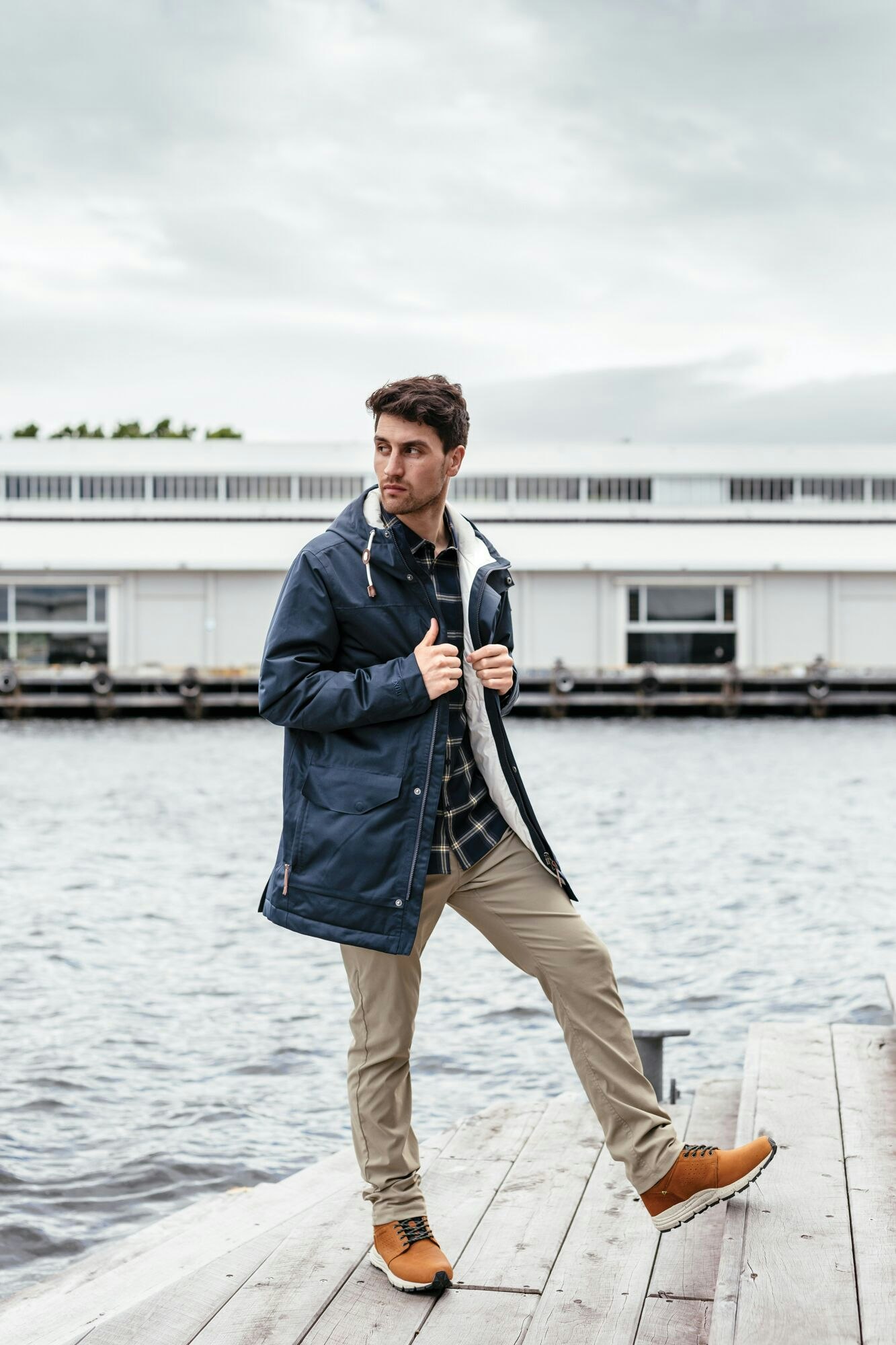 ...and the city. Image of a man posing in the Stockton Jacket on a pier