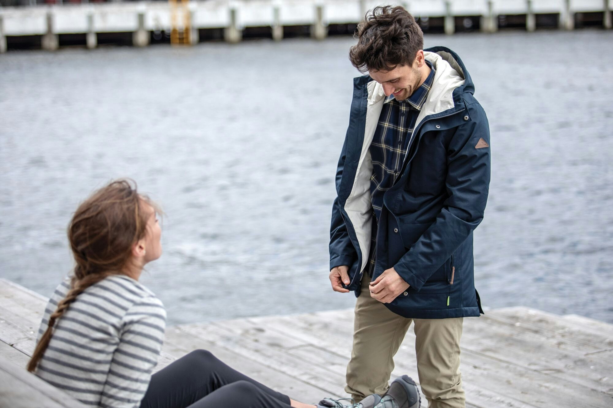 Sleek, functional with three layers of recycled materials. Image of a man inspecting the layers of the eco-friendly stockton jacket.