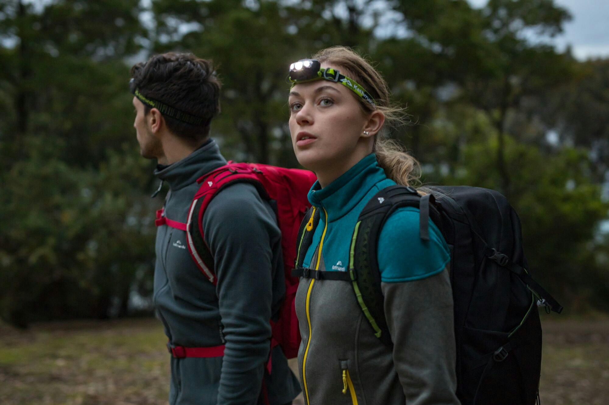 Weighing just 48g, the Torino fleece offers great warmth for weight. Image of a woman wearing the Torino fleece and a headlamp