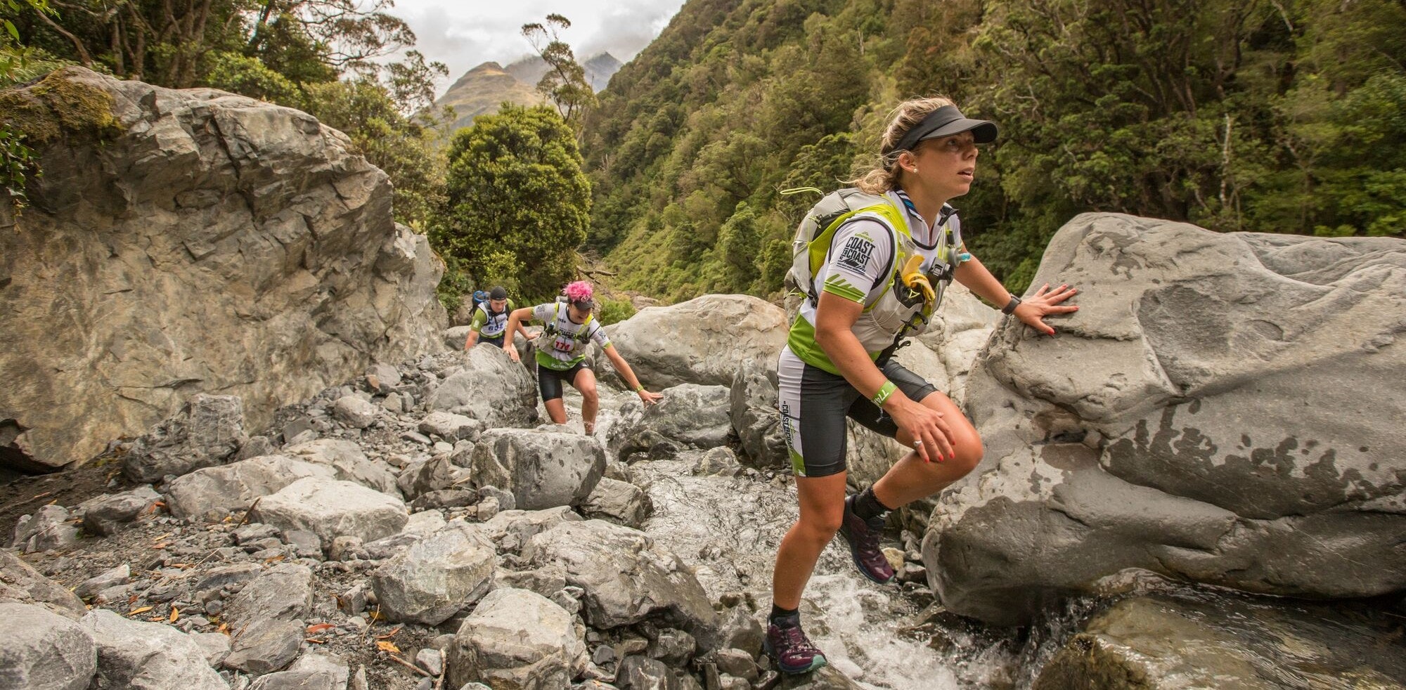 Woman running across rocks in New Zealand