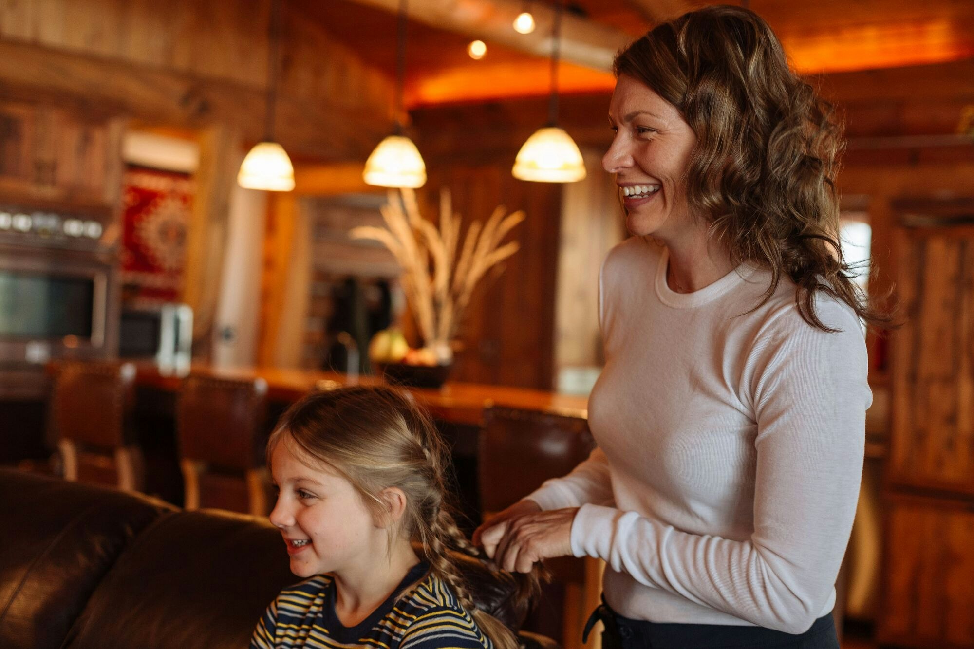 Woman wearing KMD Core base layer braiding childs hair