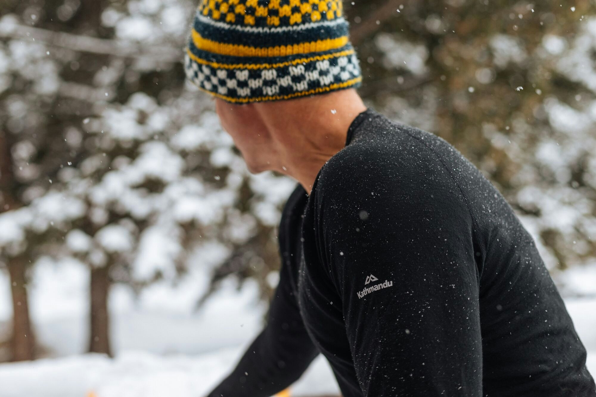 Man wearing a wool hat and KMD Ascent base layer in the snow